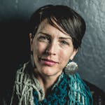 Close-up portrait of a stylish woman with short hair and bold earrings, exuding confidence.